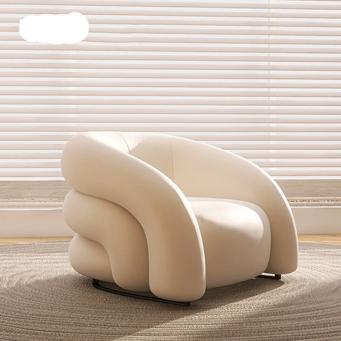 Modern beige armchair in a room with light-colored walls and floor.