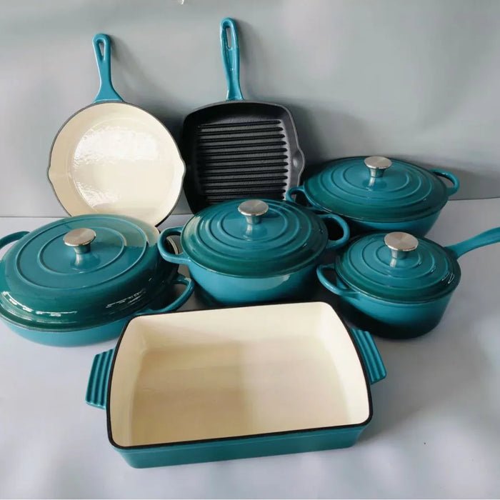 Collection of teal cookware including pots, pans, and a roaster on a white surface.