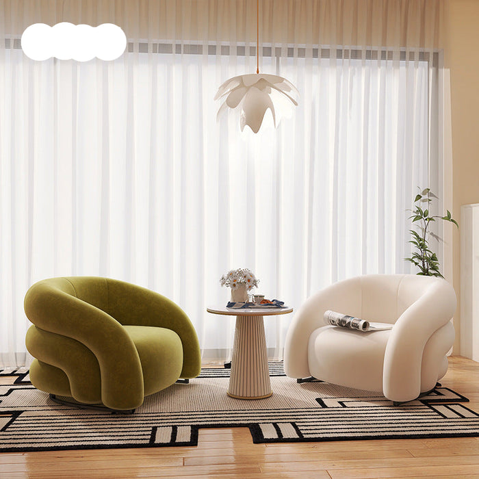 Modern living room with two curved armchairs, a small table, and decorative elements.