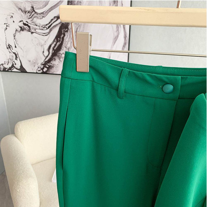Green pants on a hanger against a neutral background
