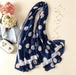 Navy blue scarf with white polka dot pattern on a light surface with decorative items.