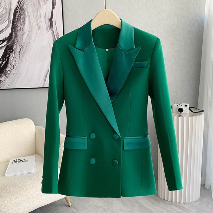Green blazer on a hanger against a neutral background