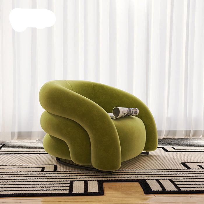 Green armchair on a patterned rug with white curtains in the background