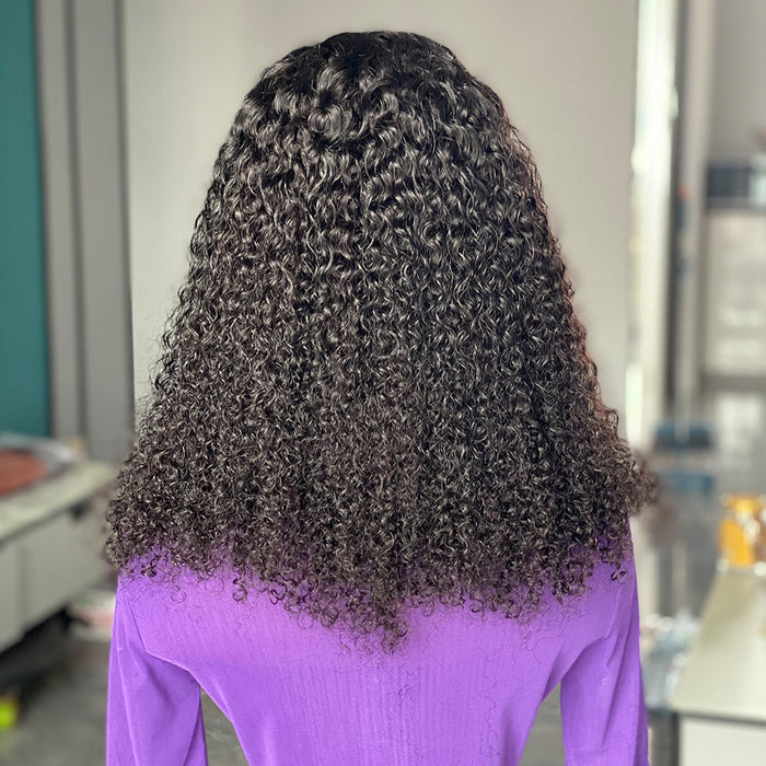 Person with curly hair wearing a purple shirt in an indoor setting