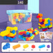 Multicolor children's building block set with a clear plastic storage bin, loose blocks, two assembled toy vehicles, and small instruction sheets on a purple studio background.