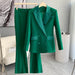 Green suit on a hanger against a neutral background