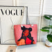 Pink tote bag with a graphic design of a woman on a white surface with a 'Vogue' magazine in the background.
