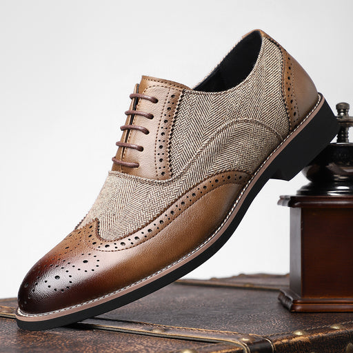 Brown and beige patterned dress shoe on a wooden surface with a neutral background