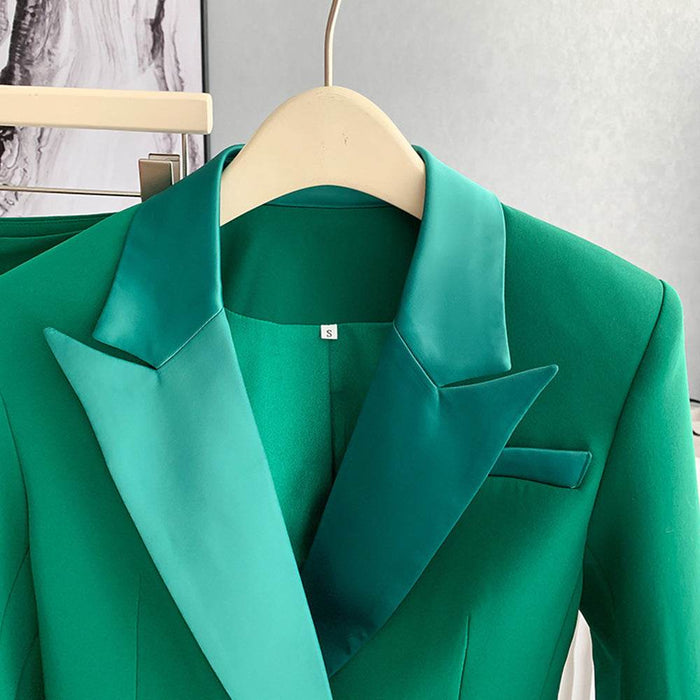 Green blazer on a hanger against a neutral background
