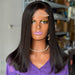 Mannequin head with a black wig and purple top in an indoor setting