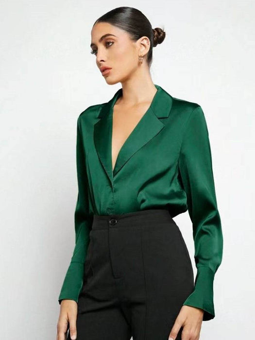 Woman wearing a green blouse and black pants on a white background