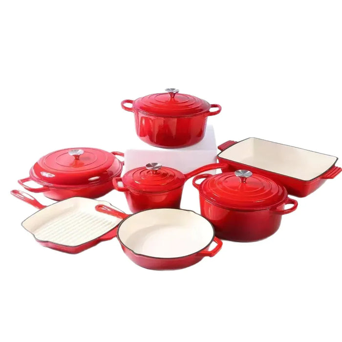 Set of red enameled cookware with white interiors on a white background