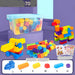 Multicolor children's building block set shown with a clear storage bin, assembled toy trains, a colorful bird figure, loose blocks, and small instruction/stickers, on a purple studio background.