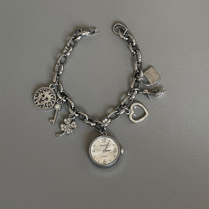 Silver charm bracelet with various charms on a gray background
