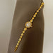 Gold bracelet with a watch face on a brown mannequin