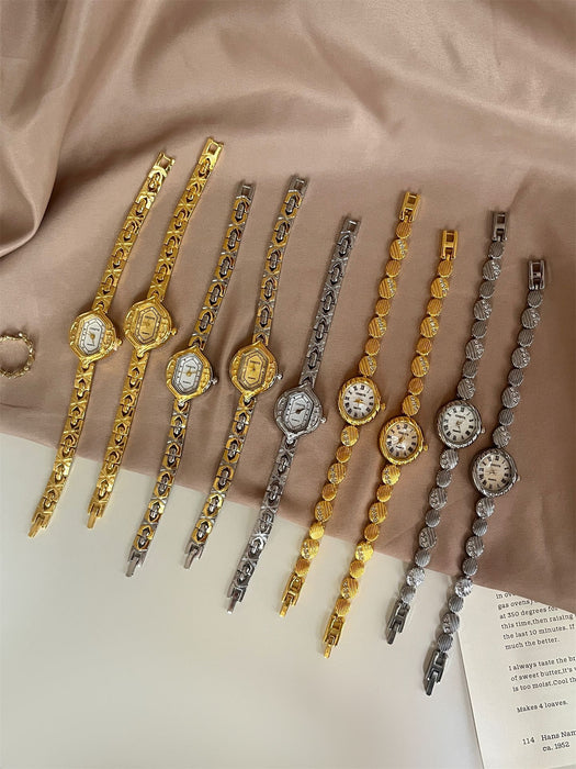 Set of gold and silver bracelets on a beige fabric background