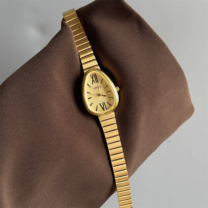 Gold wristwatch on a brown fabric background