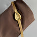 Gold wristwatch on a brown fabric background