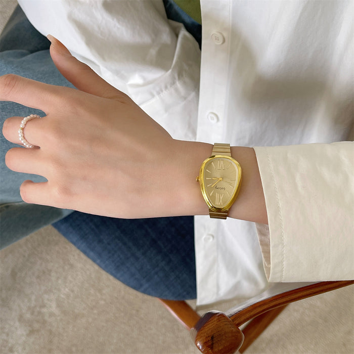 Hand wearing a gold watch with a neutral background