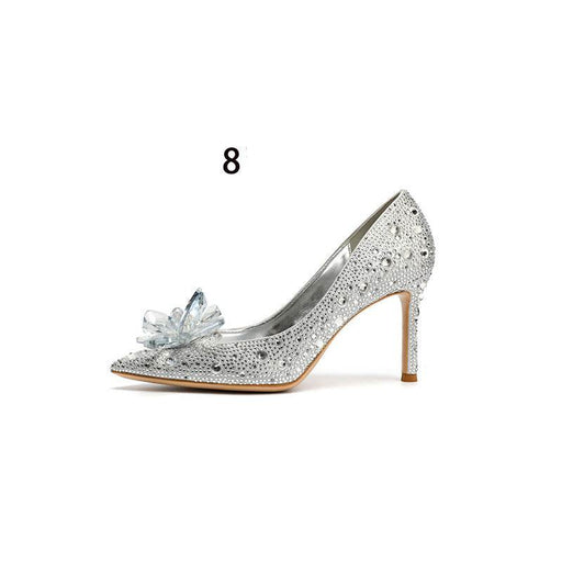 Silver high-heeled shoe with decorative flower on a white background