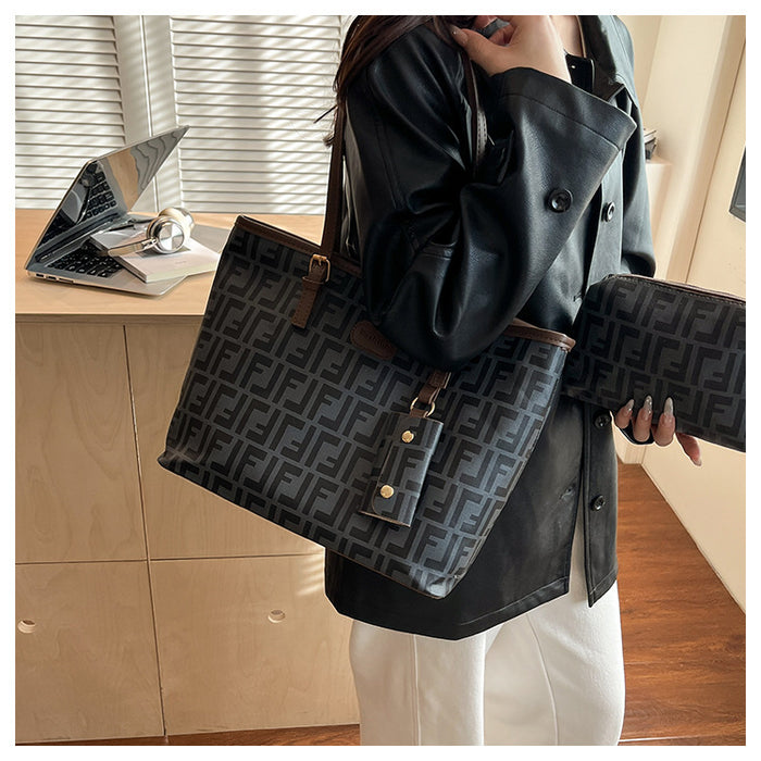 A person wearing a black double-breasted jacket and white pants carries a large black tote bag with a repeating FF monogram pattern and brown leather accents in an indoor room setting.
