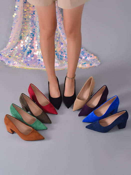 A set of women's pointed-toe high heels in multiple colors, displayed on a gray floor with a model's legs standing behind them. The shoes include black, red, olive green, brown, beige, purple, blue, and navy suede styles.