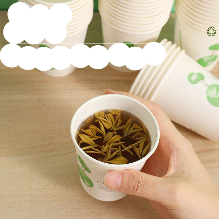 A hand holds a white paper cup with green leaf graphics, filled with tea, on a light wood table. Other stacked cups are blurred in the background, with promotional text overlaid on the top left.