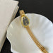 Gold watch on a white dish with a black background