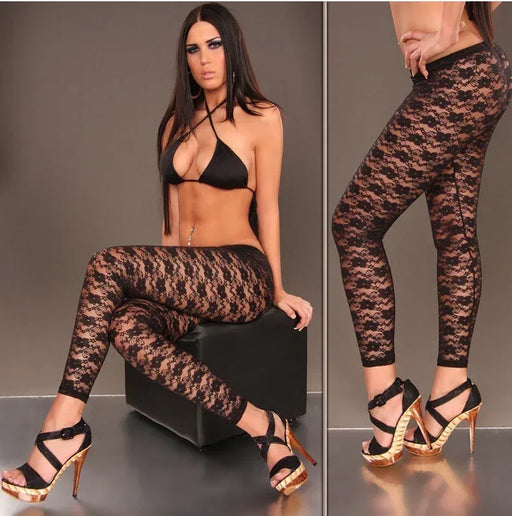 Woman wearing black lace leggings with a plain background