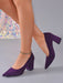 A pair of women's pointed-toe block-heel pumps in deep purple suede, shown on a model's feet against a neutral gray background.