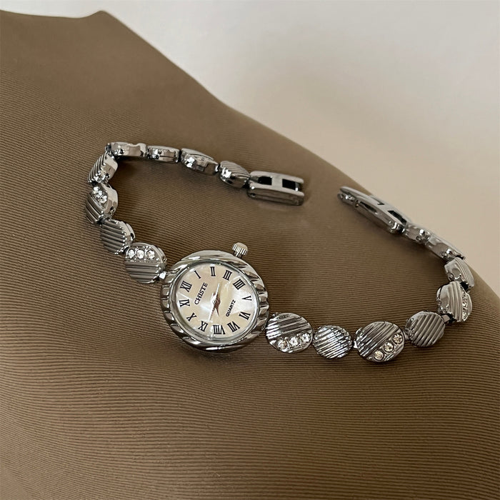 Silver bracelet with a watch face on a brown surface