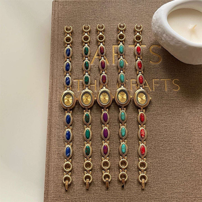 Set of colorful bracelets on a book with a candle in the background