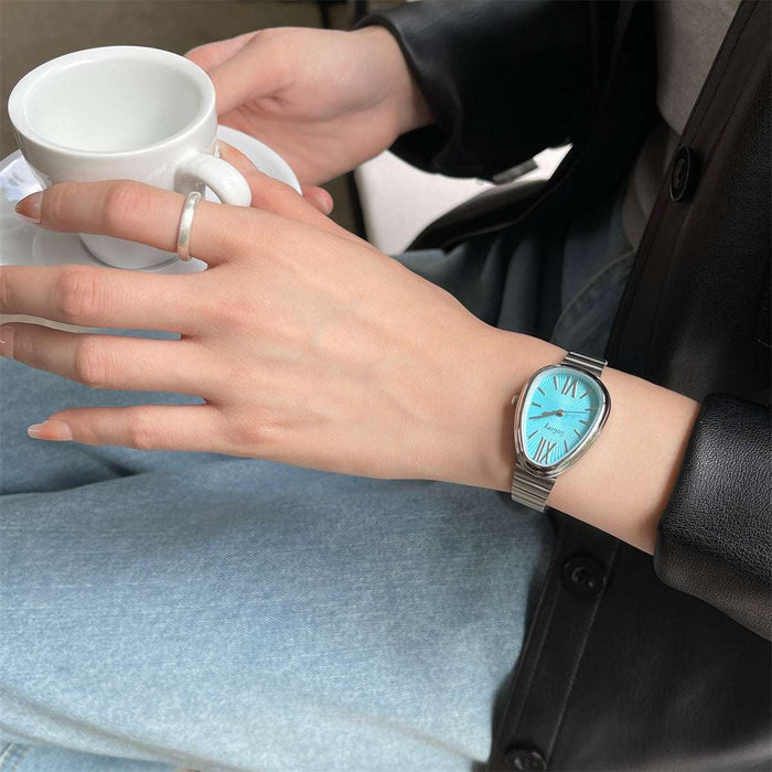 Person wearing a watch with a blue face, holding a white mug.