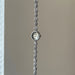 Silver bracelet with a watch face on a plain background