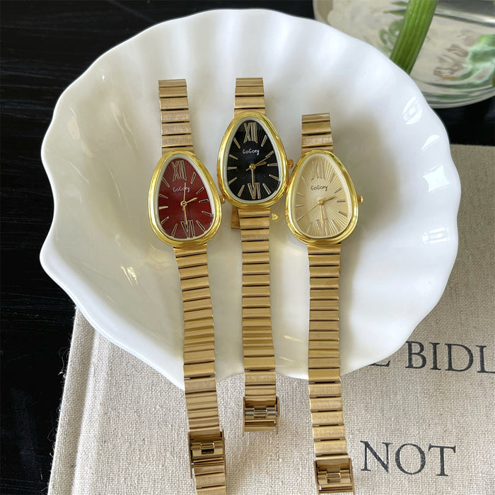 Three gold watches on a white ceramic dish with a blurred background