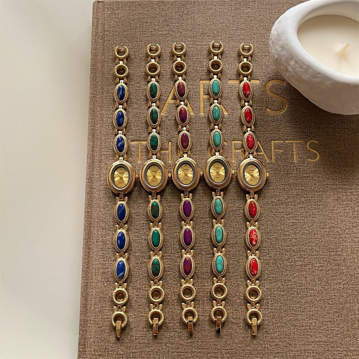 Set of colorful bracelets on a book with a candle in the background