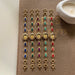 Set of colorful bracelets on a book with a candle in the background