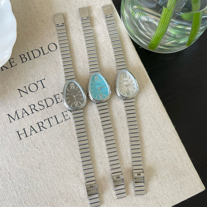 Three vintage-style wristwatches with metal straps on a textured surface.