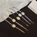 Set of five decorative hairpins with clock faces on a black surface
