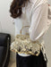 A woman wearing a white long-sleeve top and black skirt carries a small gold-tone handbag decorated with round metallic coin embellishments. The photo is taken from behind, showing the bag over her shoulder in an indoor setting.
