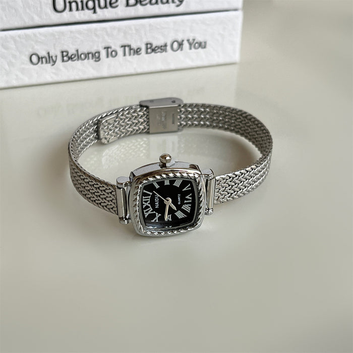Silver watch with black face on a light background