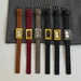 Set of six watches with different colored straps on a gray surface