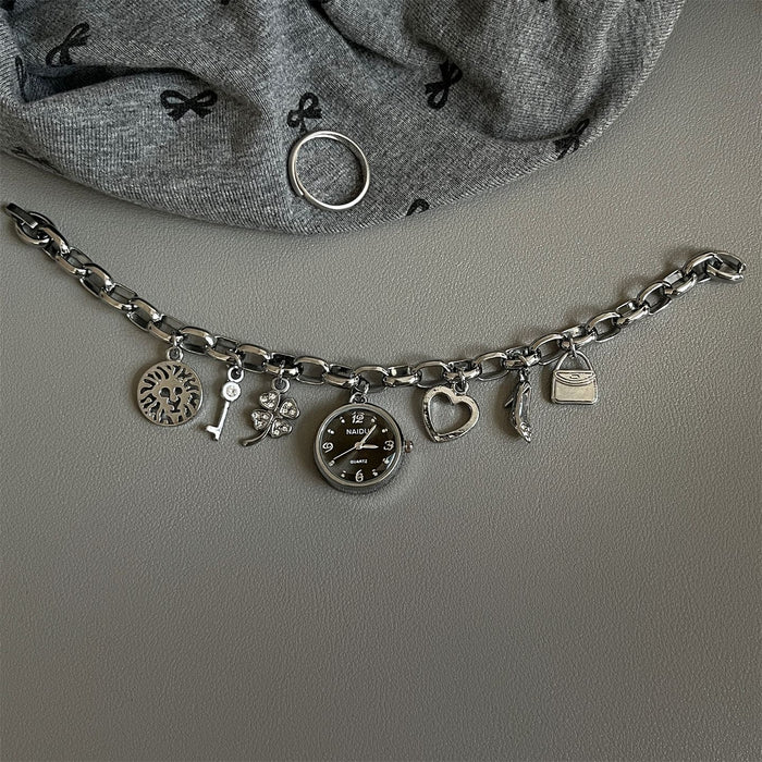 Silver charm bracelet with various charms on a gray surface