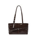 A dark brown patent leather shoulder bag with a wide top opening, a single shoulder strap, and a decorative horizontal strap with silver-tone buckles across the front.