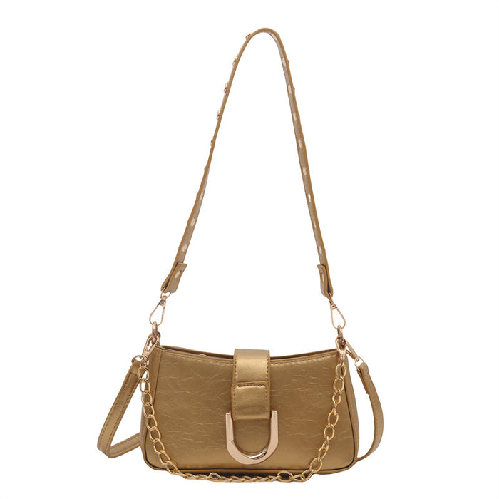 A metallic gold shoulder bag with a textured finish, featuring a gold chain strap, a long shoulder strap, and a gold D-ring closure on a plain white background.