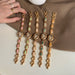 Set of gold bracelets with colorful stones on a neutral background