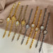Six women's watch bracelets displayed in both gold and silver tones, arranged diagonally on a beige satin fabric background with a page of text in the corner.