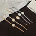 Set of five decorative hairpins with clock faces on a black surface