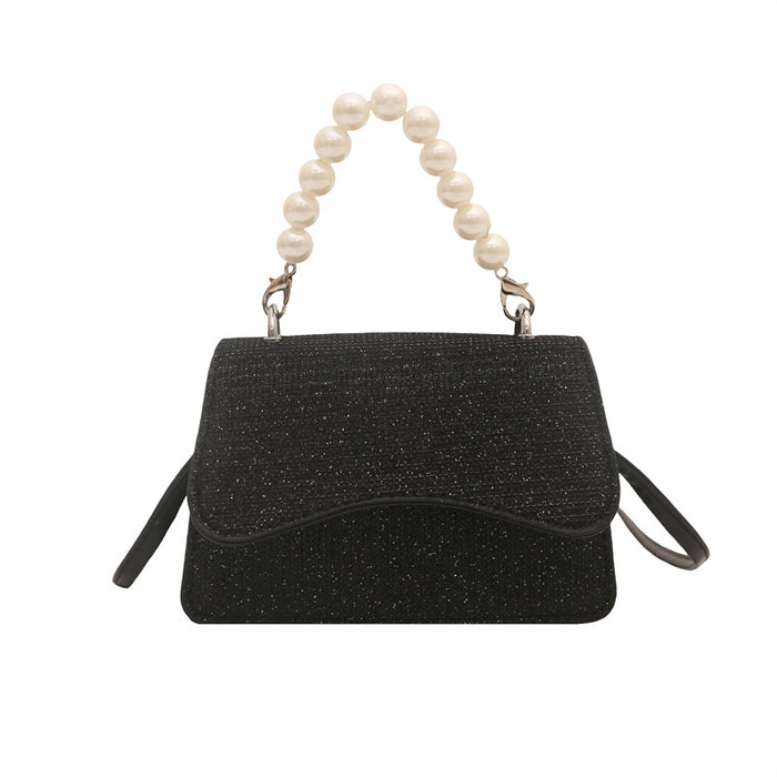 Black handbag with pearl handle on a white background