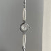 Silver watch with pearl strap on a gray background